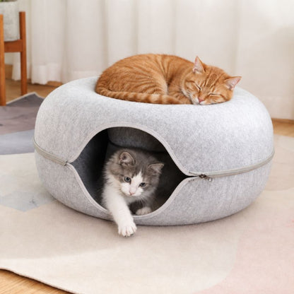Panier chat donut gris clair avec un chat joueur dedans et un chat endormi dessus.
