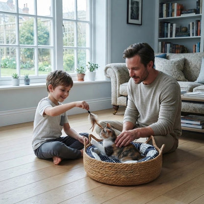 Enfant jouant avec un chat dans un panier en osier, accompagné d’un adulte