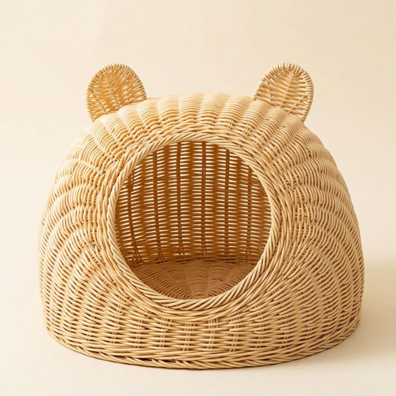 Panier en rotin pour chat seul sur fond ivoire, avec ouverture ronde, fond tressé et deux oreilles décoratives