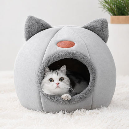 Panier pour chat grotte gris avec un chat regardant l’objectif.