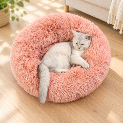 Panier pour chat moelleux rose avec un chat blanc allongé.