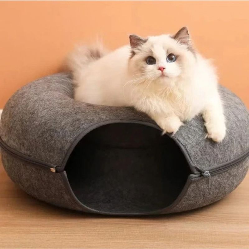Panier chat donut gris foncé avec un chat allongé dessus.